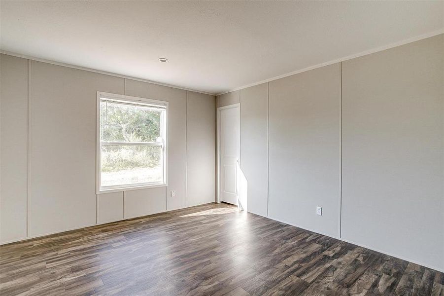 Empty room with crown molding and dark hardwood / wood-style floors