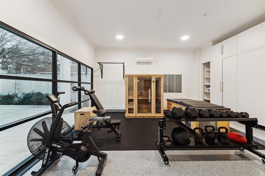 The home's 2 car garage is currently being utilized as a custom gym featuring epoxy flooring, custom built-in cabinets, large, black-framed windows, and a dedicated air conditioning unit. Even the toughest workout would be enjoyable in this room! You will love the lighting and view to the outdoors!