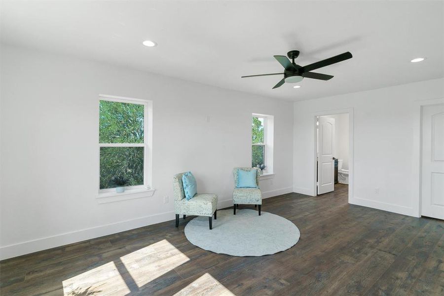 Living area featuring dark wood-type flooring and ceiling fan