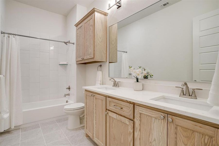 Full bathroom with natural stained custom cabinetry - soft close doors and drawers - Quartz countertops.