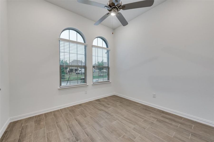Spare room featuring plenty of natural light, ceiling fan, and light hardwood / wood-style flooring