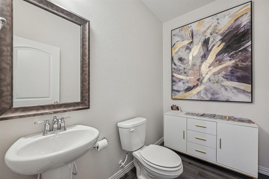 Half bathroom featuring toilet, sink, and hardwood / wood-style floors