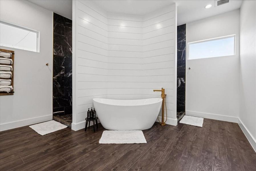 Bathroom with separate shower and tub and hardwood / wood-style flooring