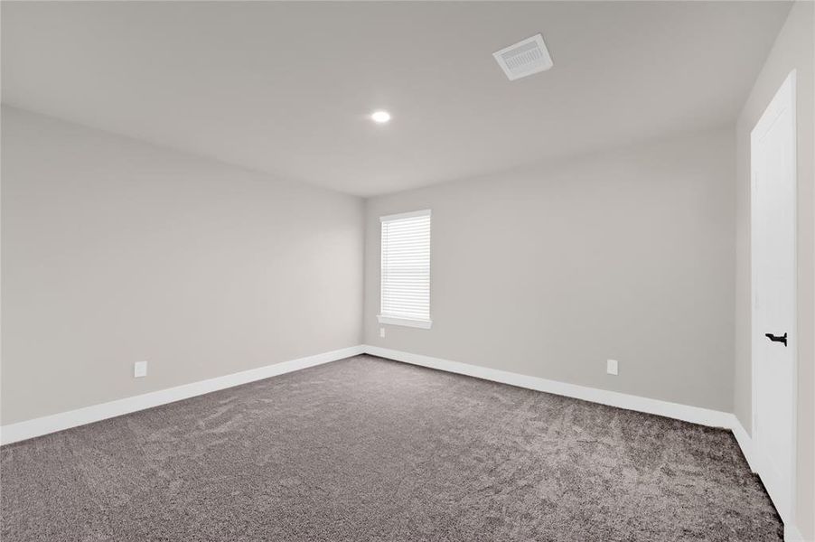 The third bedroom, also located on the second floor, offers plush carpeting, flush LED lighting, neutral paint, walk-in closet, and plentiful natural lighting.
