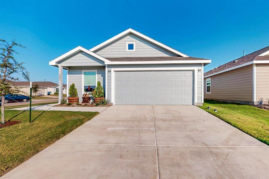 Single story home featuring a garage and a front lawn