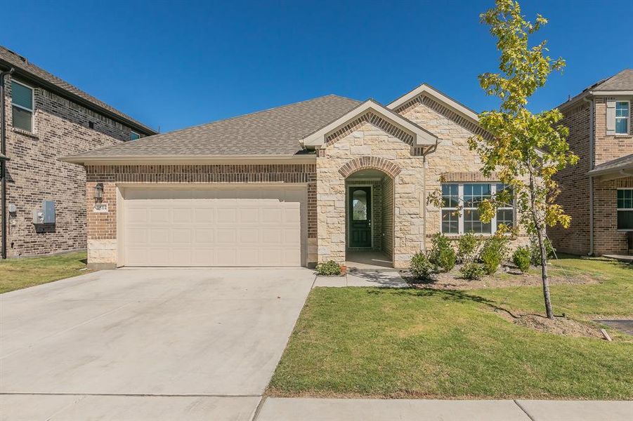 View of front of house featuring a front yard and a garage