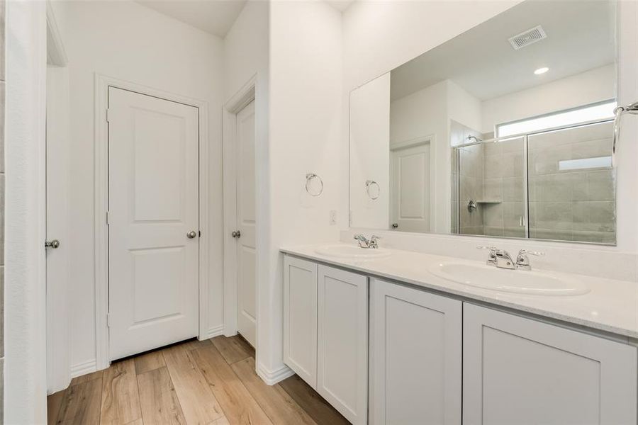 Bathroom featuring hardwood / wood-style floors, a shower with door, and vanity