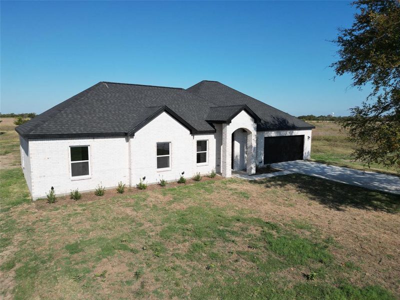 View of front of house with a front lawn and a garage