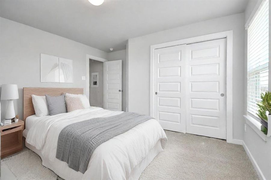 *Virtually Staged* Secondary bedrooms showcase 5-panel doors adorned with modern hardware, large windows enhanced by privacy blinds, and spacious closets featuring sleek and contemporary finishes. Sample photo of completed home with similar floor plan. Actual colors and selections may vary.