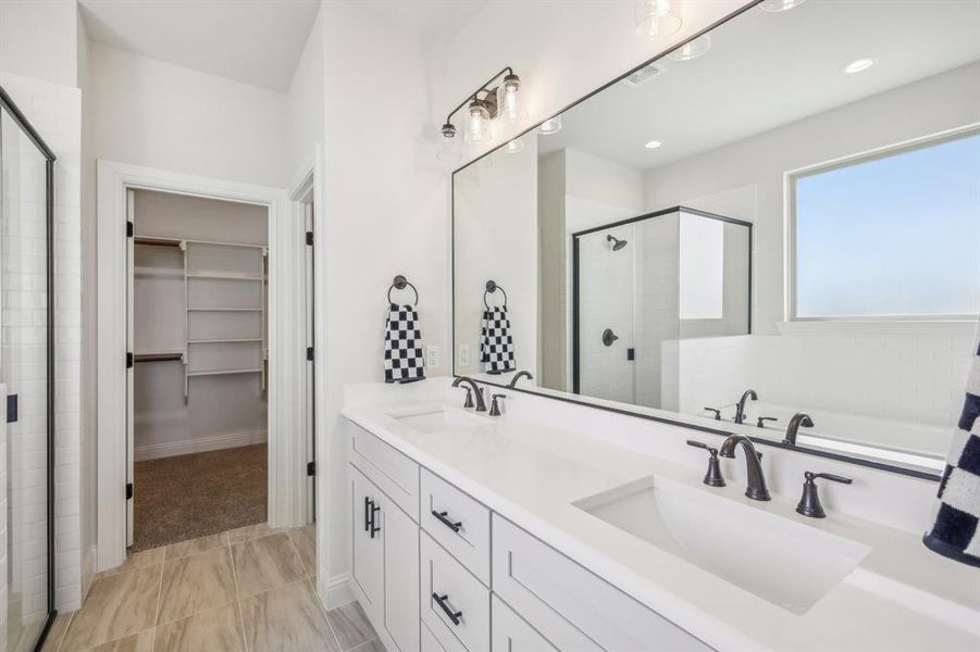 Bathroom featuring tile patterned flooring, dual vanity, and independent shower and bath