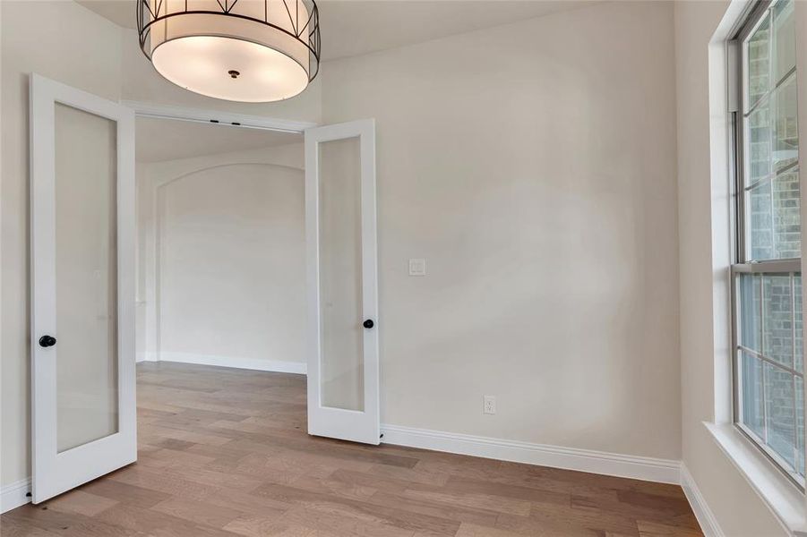 Unfurnished room with light wood-type flooring and french doors