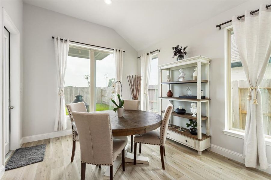 The Dining Nook is flooded with natural light from the glass back door and three windows that surround the space