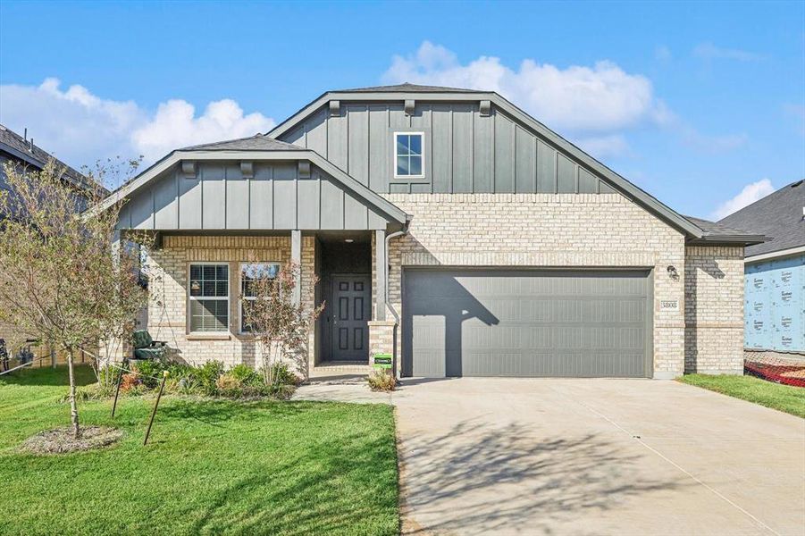 View of front of house with a front lawn and a garage