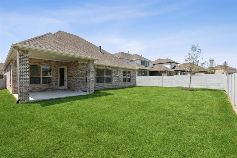 Rear view of property with a lawn and a patio