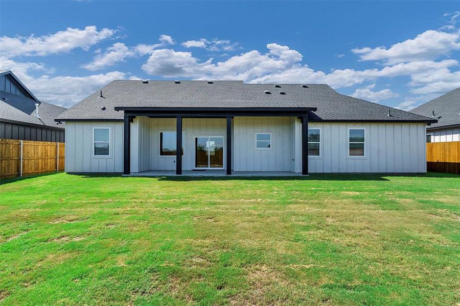 Rear view of house with a yard and a patio area