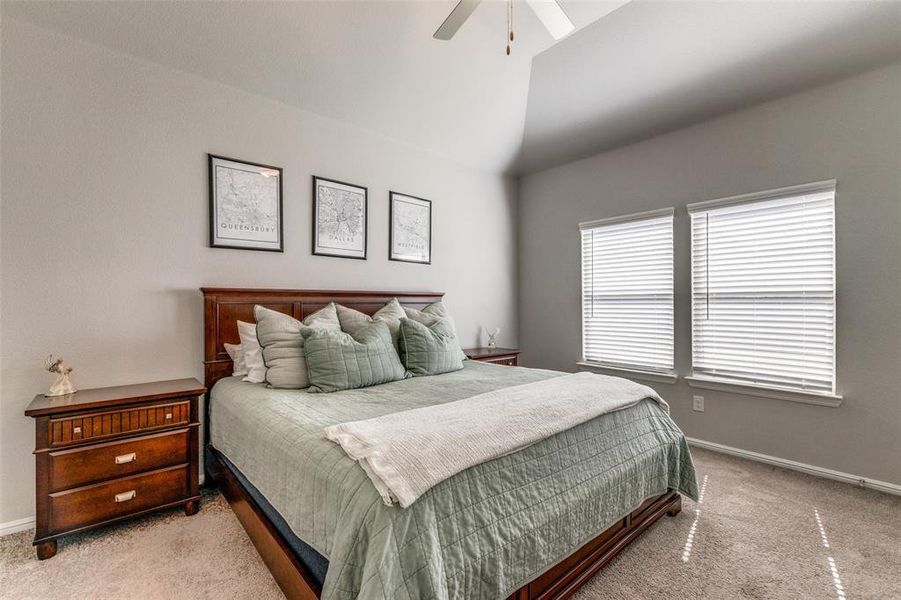 Carpeted bedroom featuring 11' sloped ceiling and ceiling fan