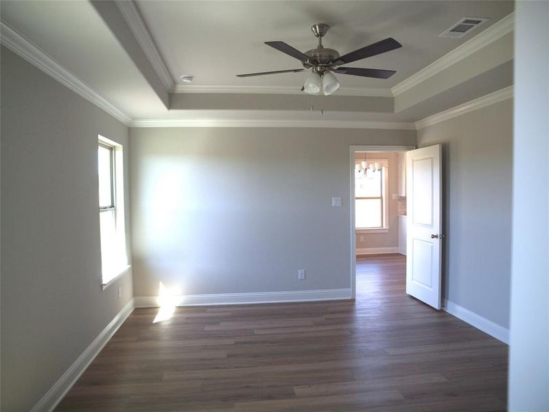 Unfurnished room featuring ceiling fan, crown molding, and dark hardwood / wood-style floors