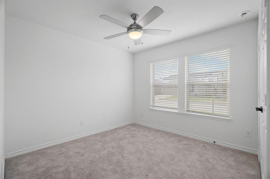 Carpeted spare room featuring ceiling fan