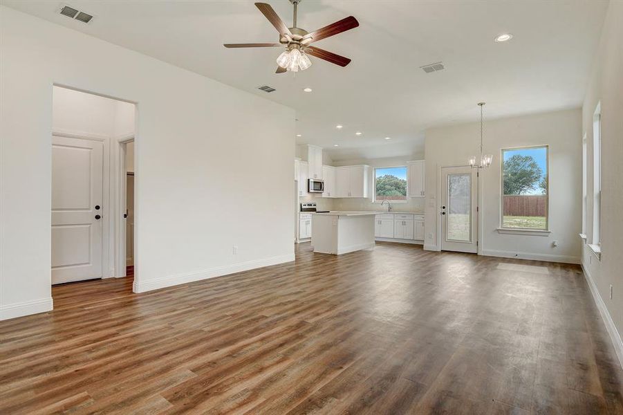 Kitchen with white cabinets, appliances with stainless steel finishes, hardwood / wood-style flooring, and tasteful backsplash