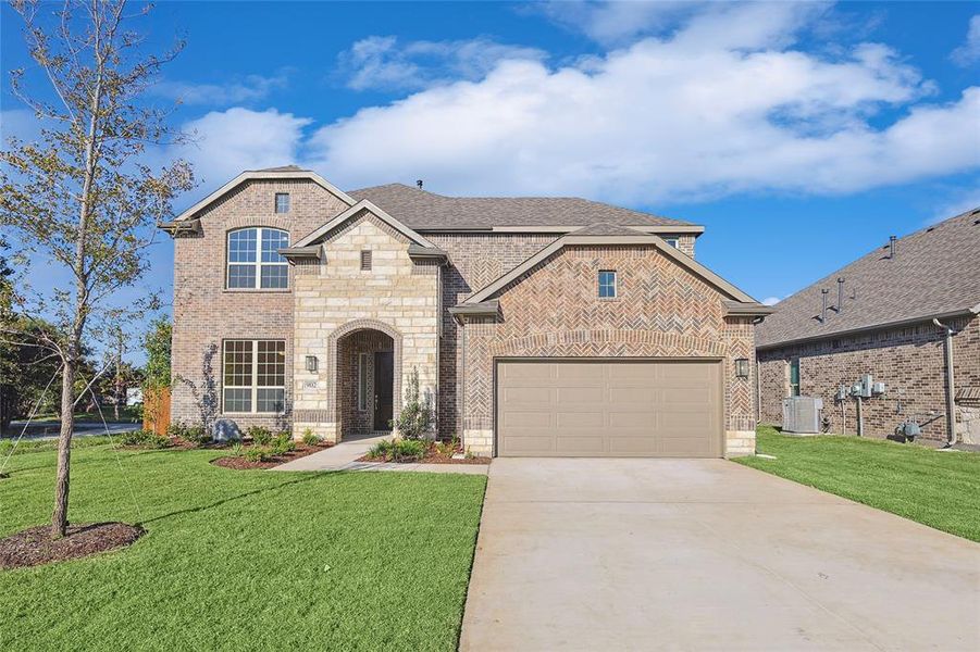 View of front of home with a garage, a front lawn, and central AC unit