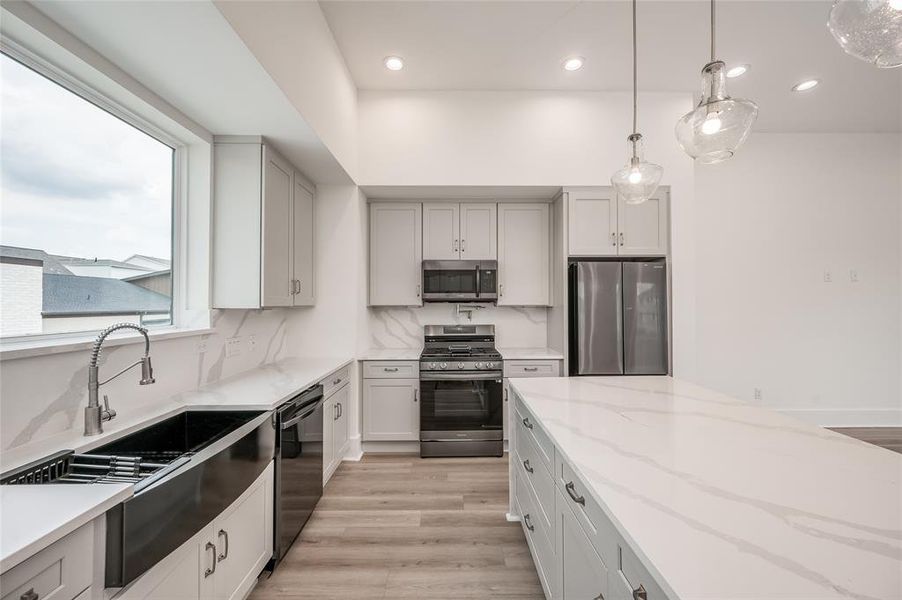 Imagine the gourmet meals you could make in this sleek kitchen featuring black-toned stainless steel Samsung appliances and quartz countertops.