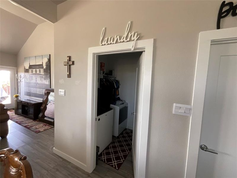 Hall featuring lofted ceiling, independent washer and dryer, and hardwood / wood-style flooring