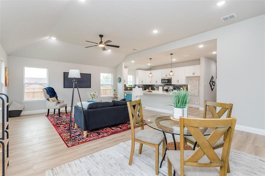 Dining area with light hardwood / wood-style flooring, lofted ceiling, and ceiling fan