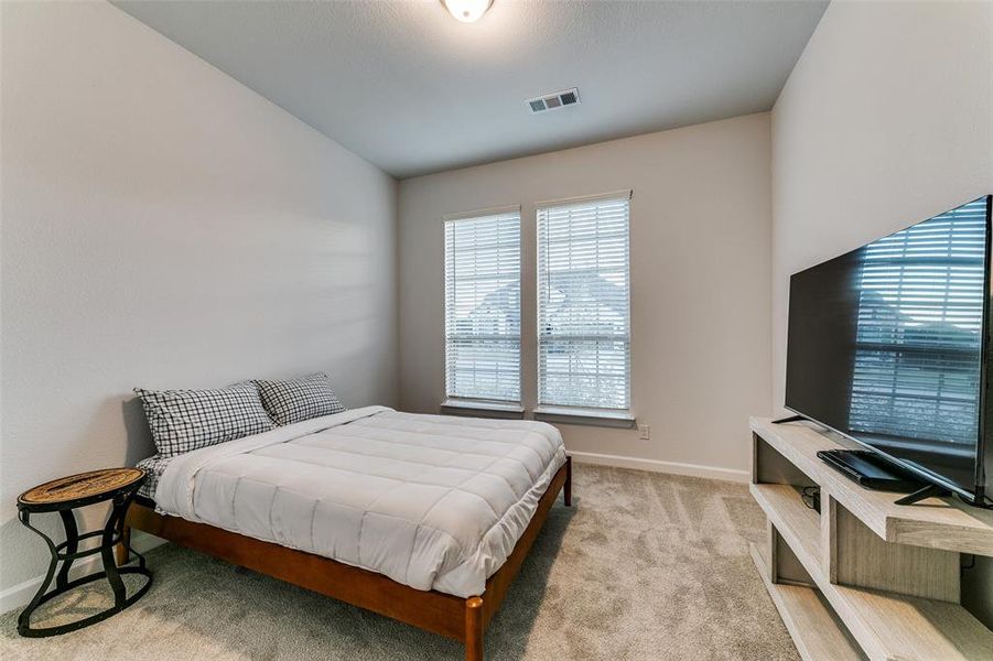 Bedroom featuring light carpet