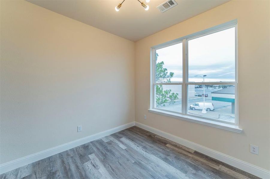 Empty room featuring hardwood / wood-style floors and a chandelier