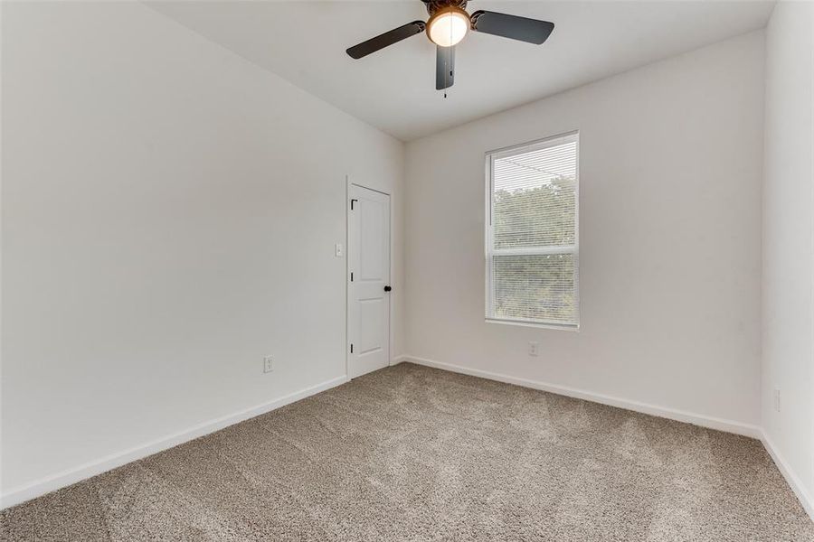 Unfurnished room with ceiling fan and carpet