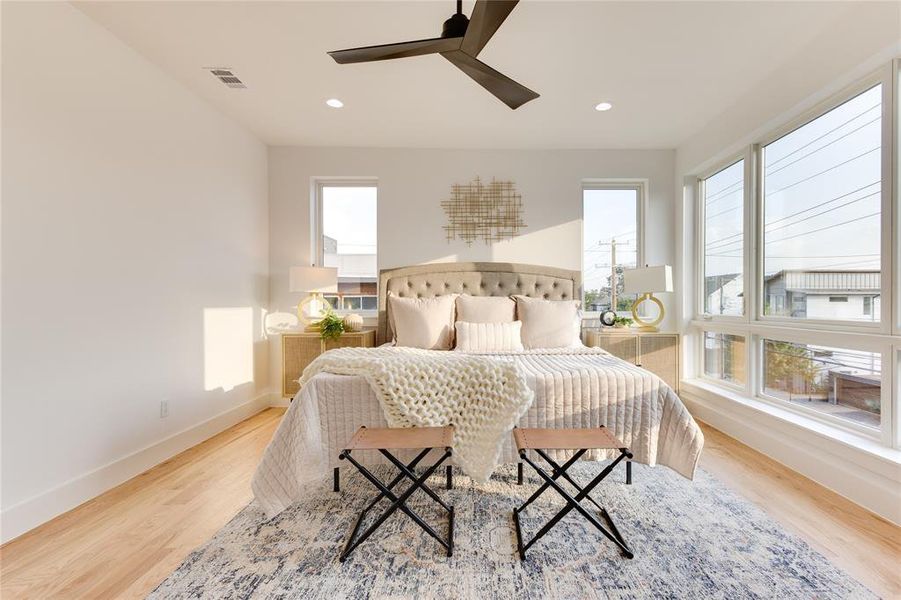 Bedroom with light hardwood / wood-style flooring, multiple windows, and ceiling fan