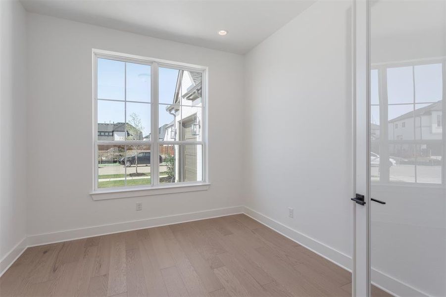 Unfurnished room with light hardwood / wood-style floors and a healthy amount of sunlight