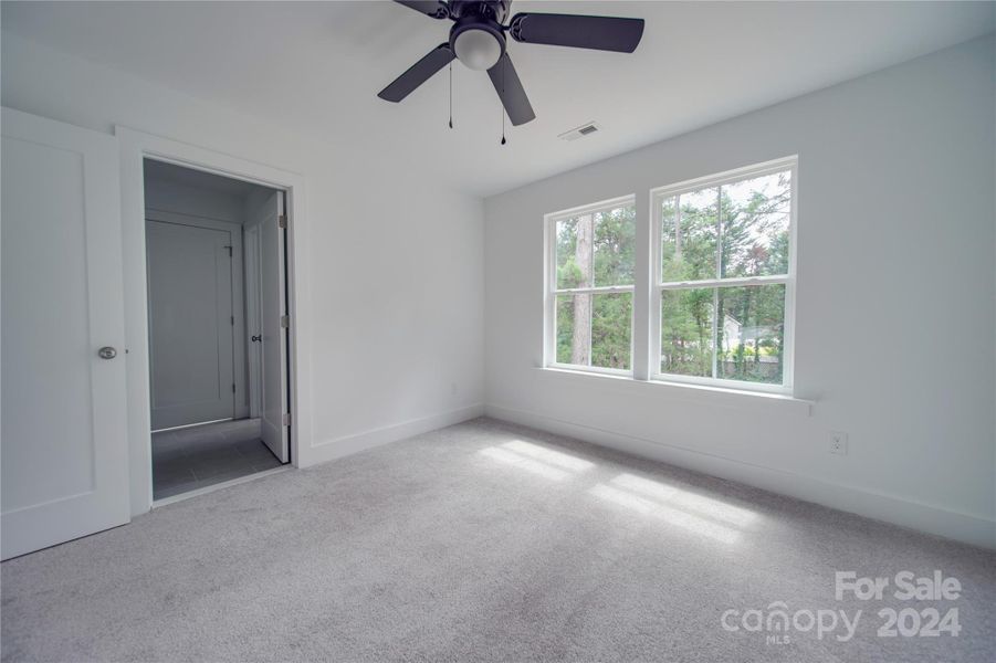 SECONDARY BEDROOM WITH CEILING FAN AND WALK IN CLOSET