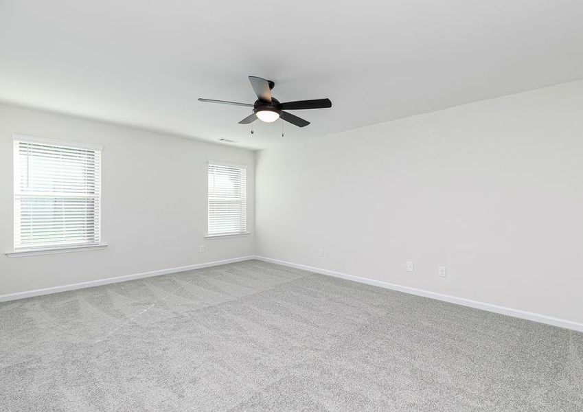 Rest and relaxation await in this beautifully lit master bedroom