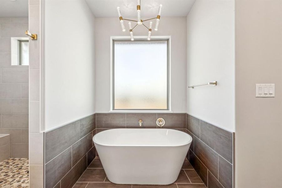 Bathroom featuring tile patterned flooring, tile walls, and a wealth of natural light