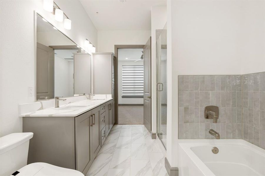 Bathroom featuring tile flooring, toilet, and dual bowl vanity