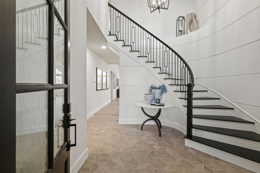 Entry Foyer with beautiful wrought iron staircase with wood treds and wall panelings.