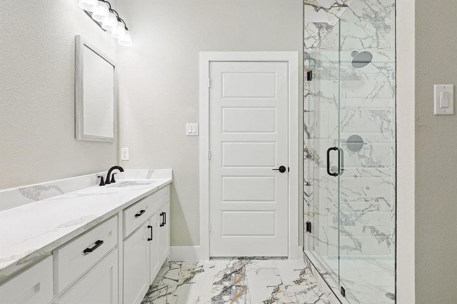 Bathroom featuring tile floors, a shower with shower door, and vanity