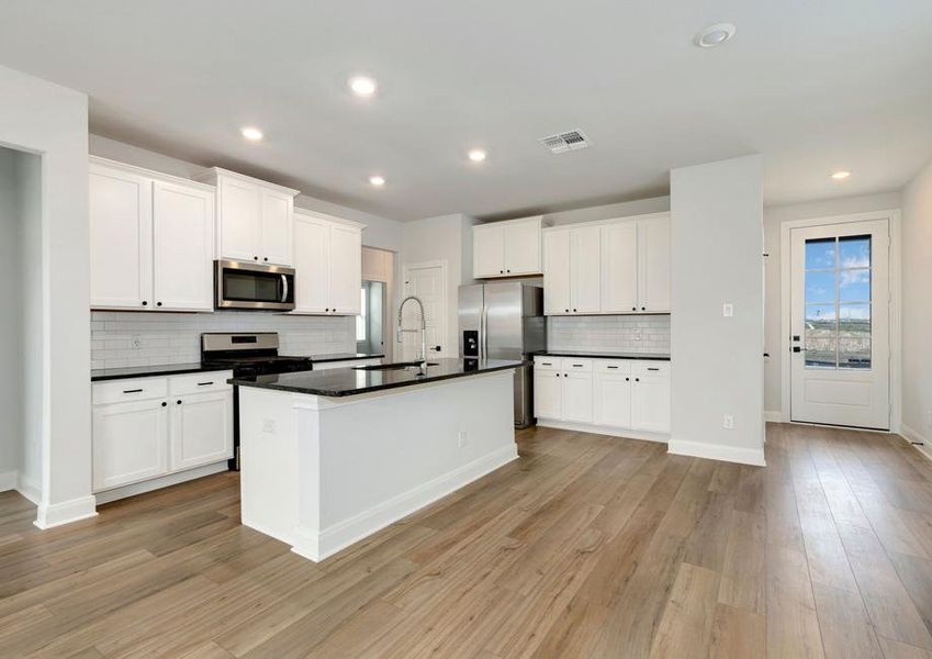 Upgraded kitchen with black countertops and white cabinetry.