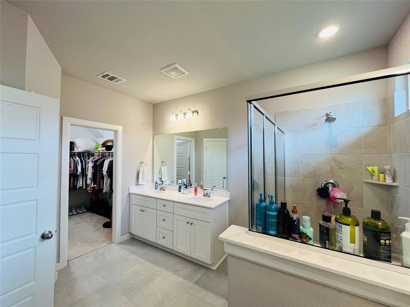 Bathroom featuring vanity and an enclosed shower