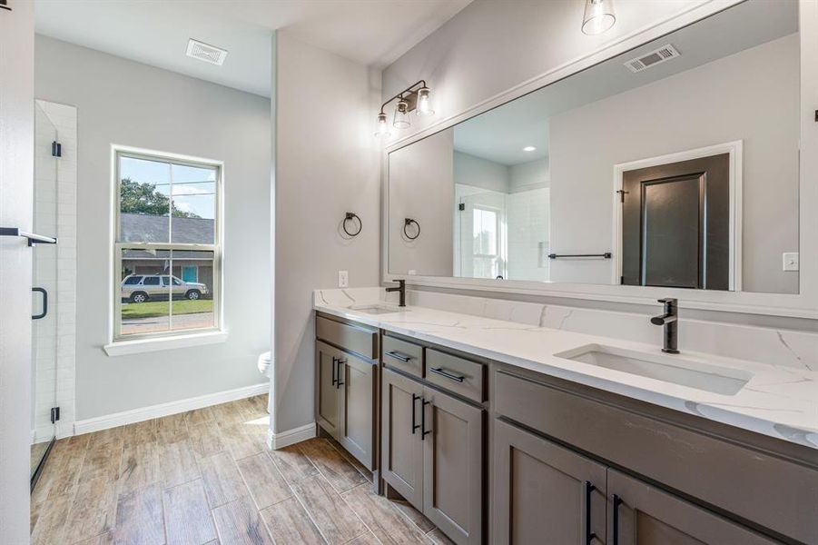 Bathroom with a shower with door, toilet, vanity, and hardwood / wood-style flooring