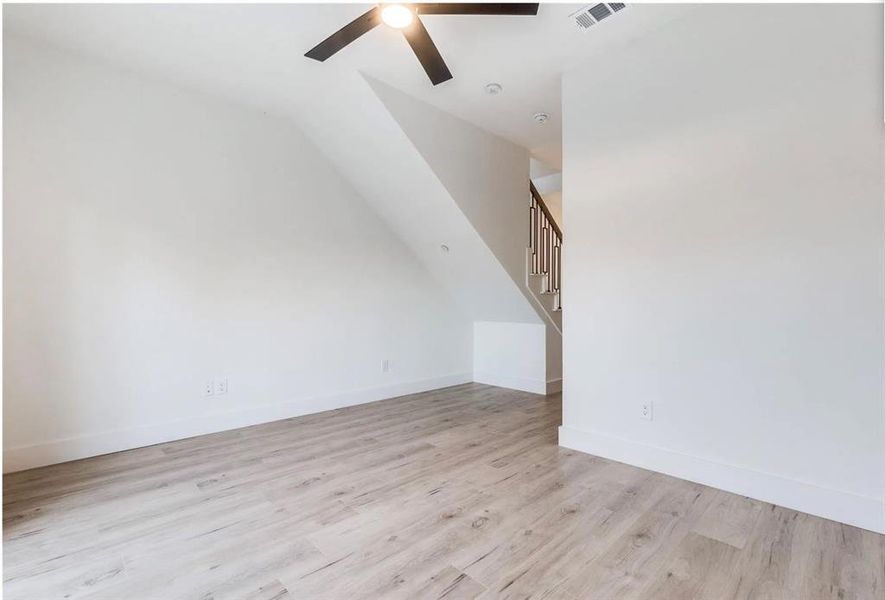 Bonus room featuring light wood-type flooring, ceiling fan, and vaulted ceiling