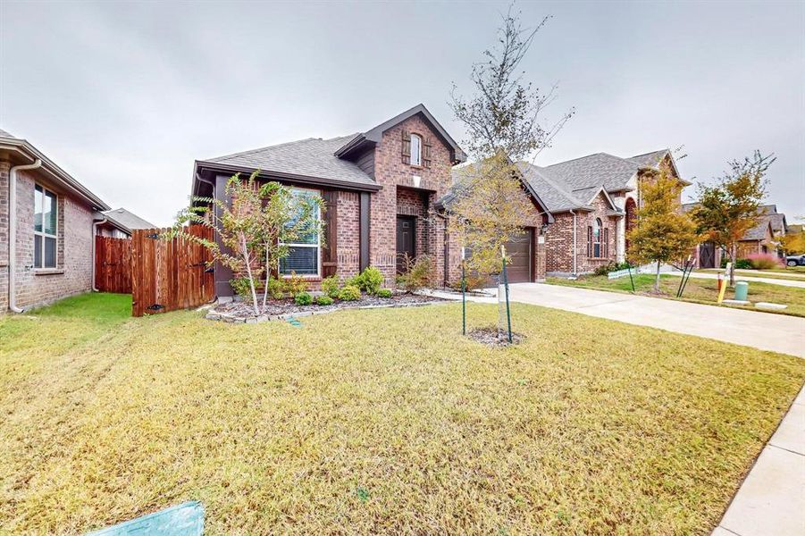 View of front facade featuring a front lawn and a garage