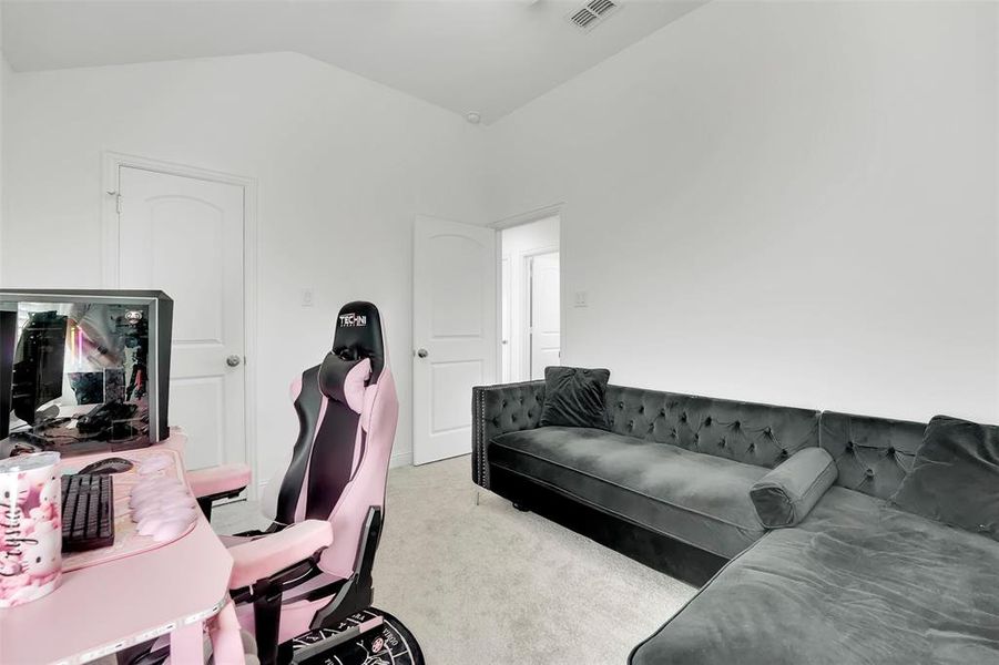 Carpeted home office featuring lofted ceiling