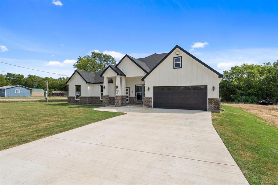 Modern farmhouse with a garage and a front lawn