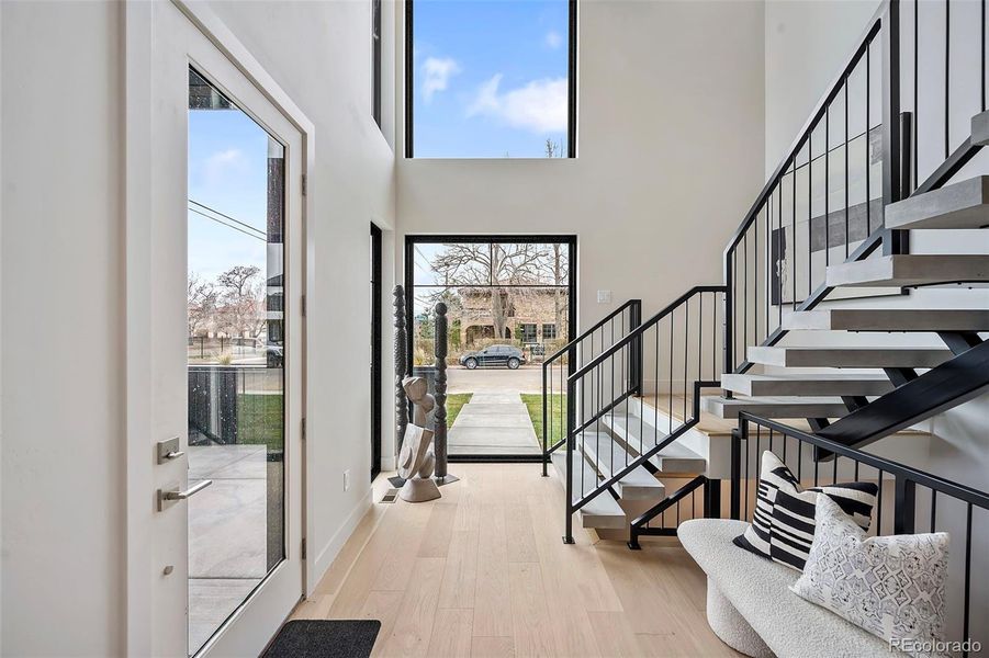 Flooded with natural light from the enormous windows highlight the stringer staircase with concrete treads.