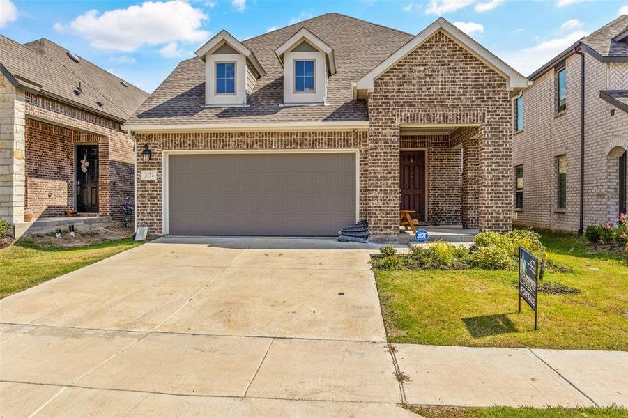 View of front facade with a garage and a front lawn