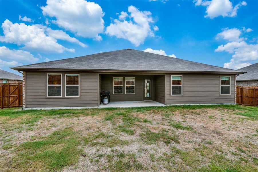 Rear view of house featuring a patio area and a yard