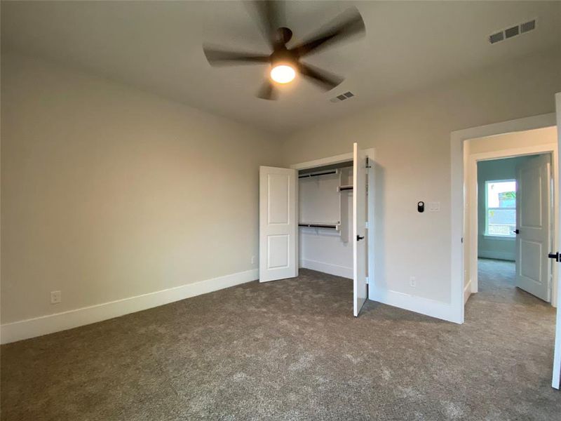 Unfurnished bedroom featuring carpet flooring, a closet, and ceiling fan