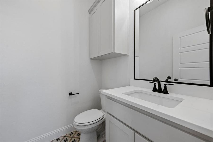 Bathroom with tile floors, toilet, and large vanity